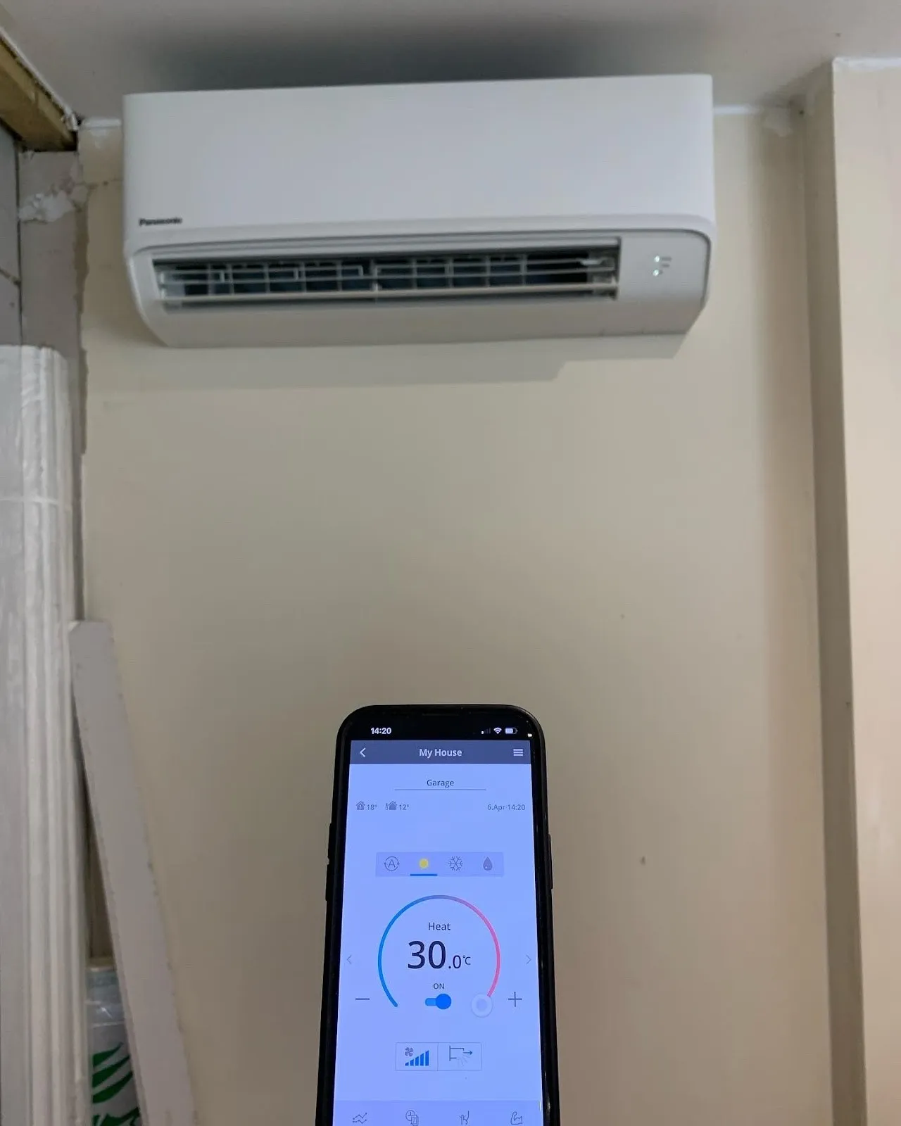 A Panasonic wall unit set to heat at 30°C, controlled from a phone app