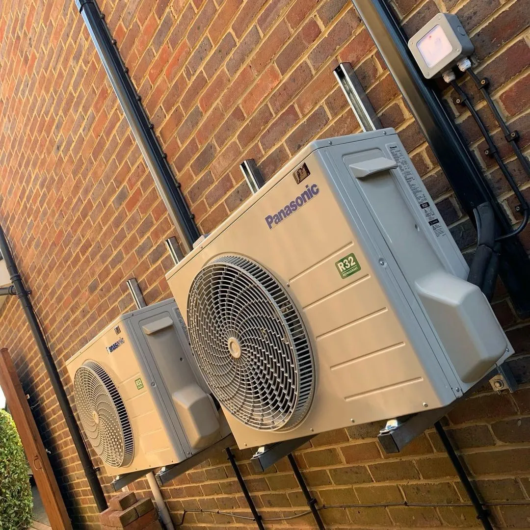 Two Panasonic outdoor heat pump units fitted on a brick wall